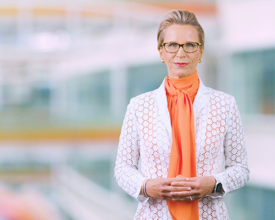 GSK CEO Emma Walmsley in orange shirt and white jacket