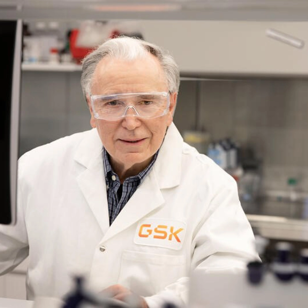 Scientist in a lab wearing white lab coat and goggles