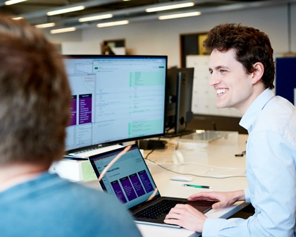 Man sitting at desk with laptop and computer screen