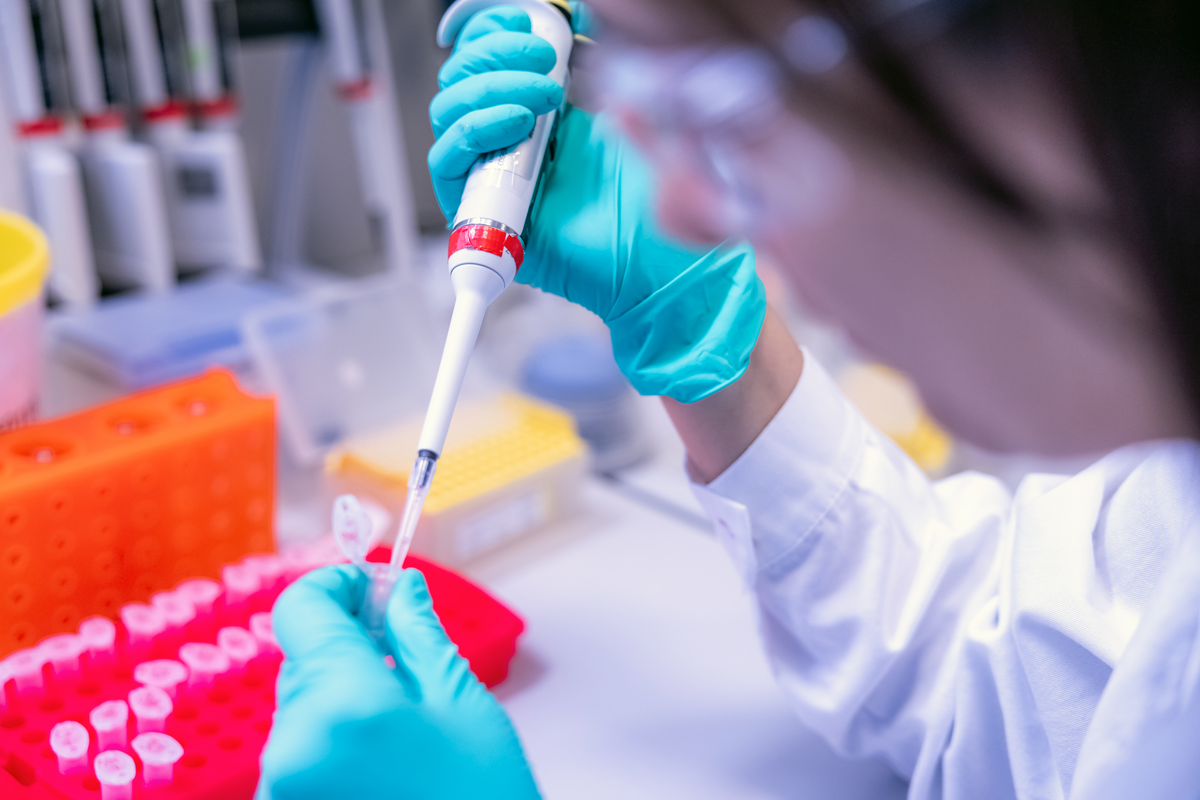 Scientist using syringe and test tube