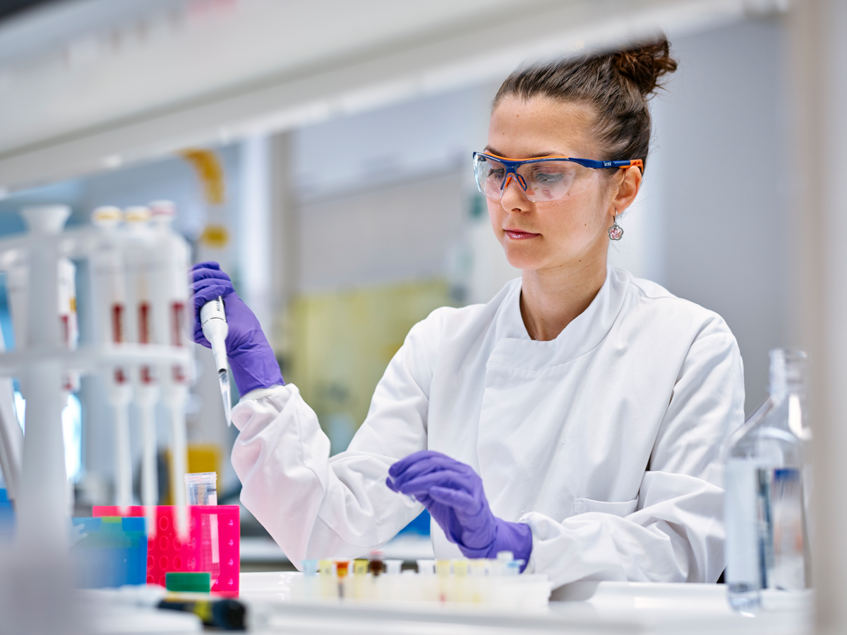 Scientist uses pipette with test tubes