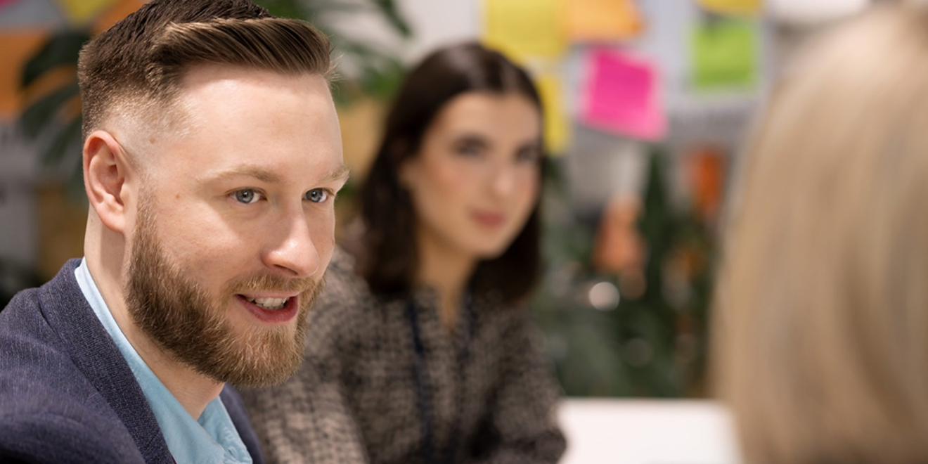 Man and woman smile while listening during a meeting