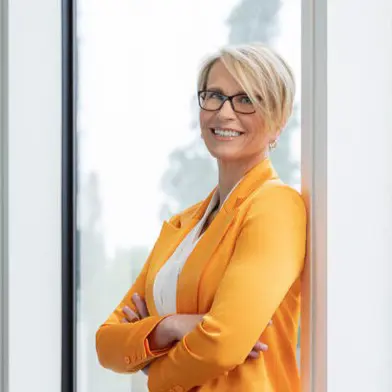 Emma Walmsley CEO wearing orange suit and smiling
