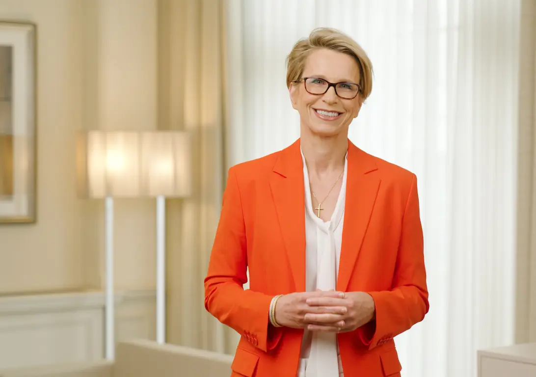 CEO Emma Walmsley smiling in orange jacket