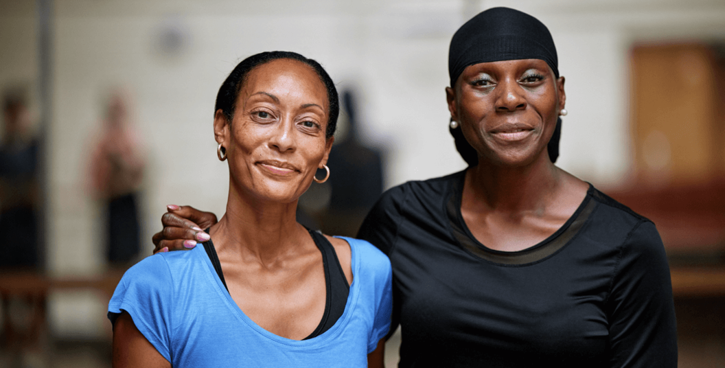 Two patients smiling with their arms round each other
