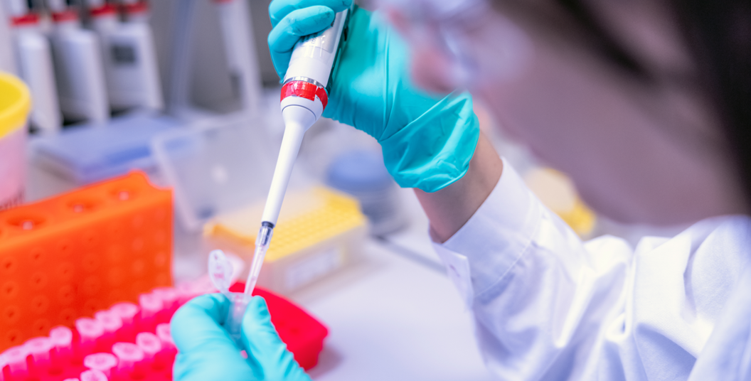Scientist using syringe and test tube