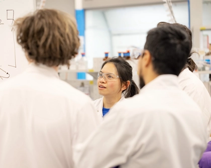 Group of employees in labcoats talking
