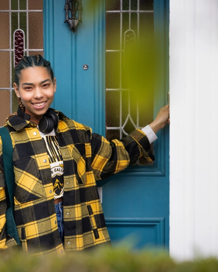 Person smiling while entering their home
