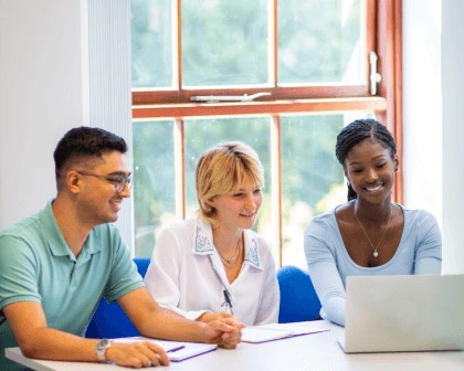 three people working on a laptop