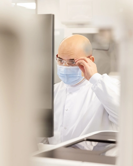 Lab worker adjusting glasses