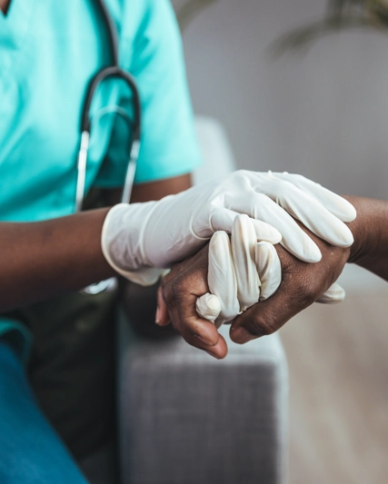 Medical professional holding a patients hand
