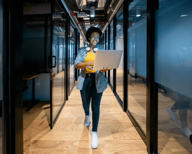 women walking with a laptop in her hand